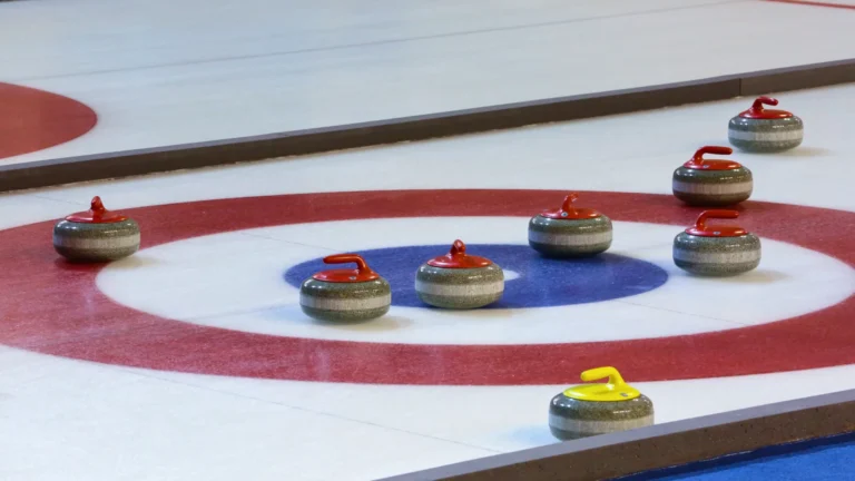 Pierres de curling sur la patinoire – pierres de curling en granit avec poignées rouges et jaunes sur la face intérieure